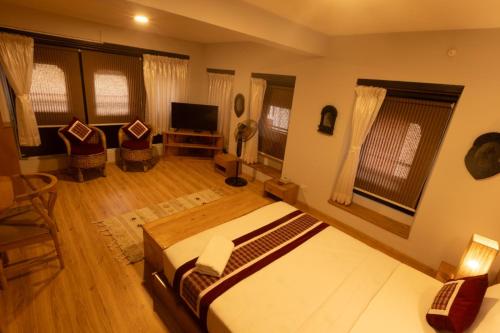 a bedroom with a large bed and a television at Subha Casa Hotel in Pātan