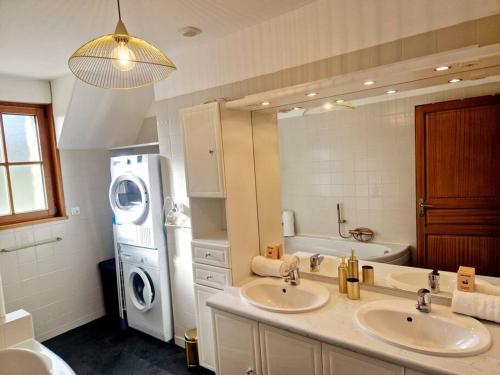a bathroom with two sinks and a washing machine at Le Panoramique in Barneville-Carteret