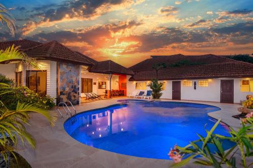a swimming pool in front of a house with a sunset at Pattaya Hill close to Walking St and City in Nong Prue