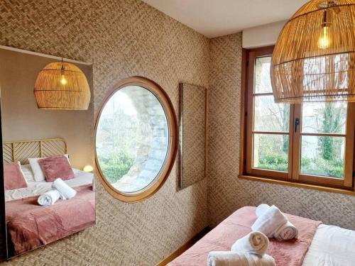 a bedroom with two beds and a mirror at Le Panoramique in Barneville-Carteret
