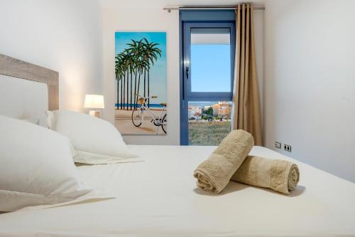 a bedroom with a white bed with towels on it at Cambrils Platja in Cambrils