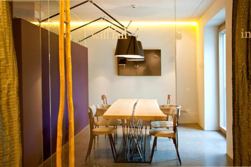a dining room with a wooden table and chairs at Nala Individuellhotel in Innsbruck