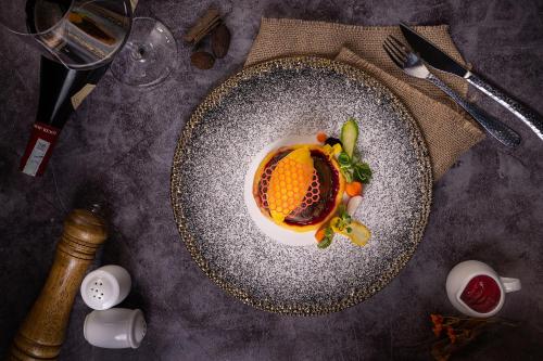 a plate of food with an orange on a table at The Oriental Jade Hotel in Hanoi