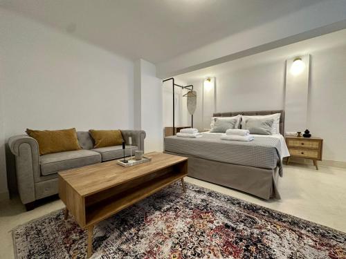 um quarto com uma cama, um sofá e uma mesa em The blue house Athens em Atenas