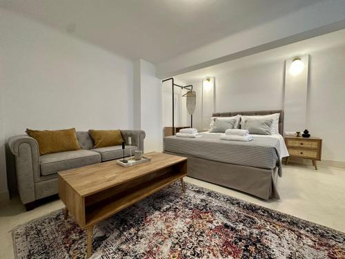 a bedroom with a bed and a couch and a table at The blue house Athens in Athens
