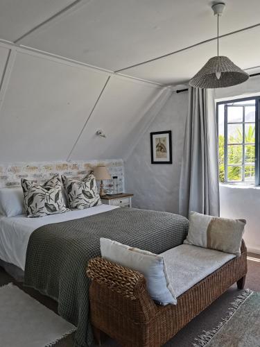 a bedroom with a large bed and a chair at Vermont Lofts in Hermanus