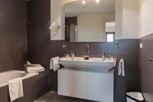 a bathroom with a sink and a tub and a mirror at Mas Montbrio Belvedere in Cambrils