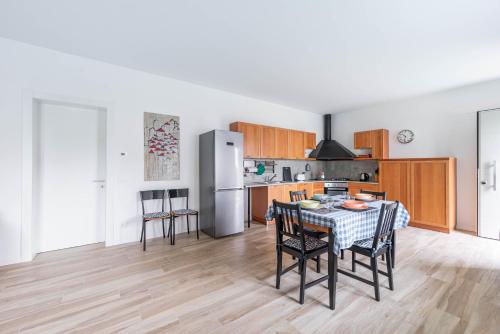 uma cozinha com uma mesa e cadeiras e um frigorífico em Guerrazzi New Flat - Parcheggio privato em Pádua