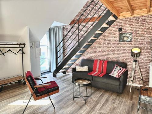 a living room with a couch and a brick wall at Le Patio de Loiseau in Le Mans