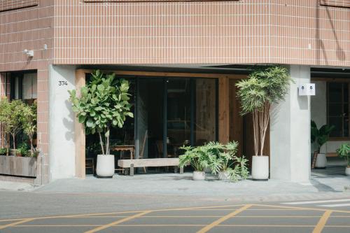 a building with a bench and potted plants in front of it at Norden Ruder Hostel Taitung Branch 2 in Taitung City