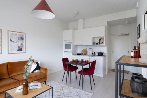 un soggiorno con un divano e un tavolo di Jewelbox in Vantaa, free parking, 15 mins to Helsinki Vantaa Airport by train a Vantaa