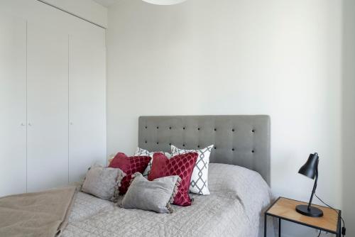 una camera da letto con un letto con cuscini rossi e bianchi di Jewelbox in Vantaa, free parking, 15 mins to Helsinki Vantaa Airport by train a Vantaa