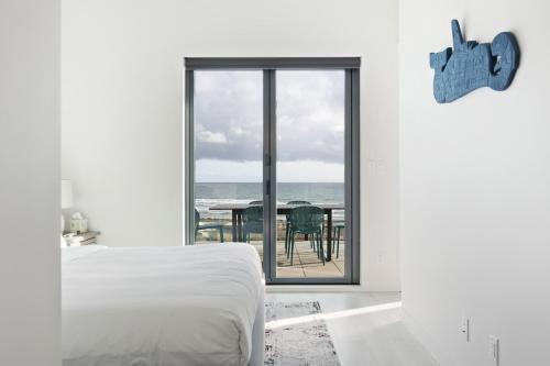 a bedroom with a bed and a view of the ocean at Beachfront Luxury Suite #15 at THE BEACH HOUSE in Campbell River