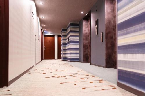 a hallway with a carpet in the middle of a building at the b sapporo in Sapporo