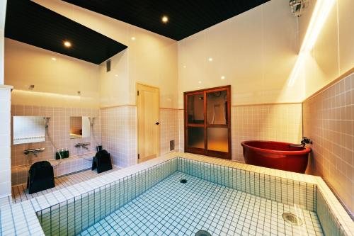 町住客室 秩父宿 في تشيتشيبو: حمام كبير مع حوض استحمام مع مرحاض وحوض استحمام