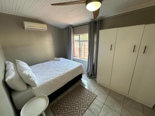 um pequeno quarto com uma cama e uma janela em 15 On Natorp em Polokwane