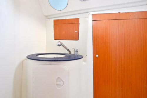 a bathroom with a sink and a wooden door at Sun odyssey 43ia in Corfu Town