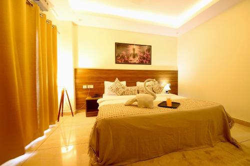a bedroom with a bed with a teddy bear on it at Perfectstayz Value Forest Valley Near Waterfall in Rishīkesh