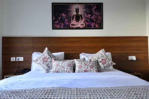 a bed with pillows and a picture of a skull at Perfectstayz Value Forest Valley Near Waterfall in Rishīkesh