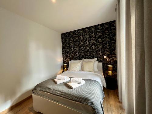 une chambre avec un lit avec deux serviettes dessus dans l'établissement LesCinqSuites / Le Chivas - DABNB, à Limoges