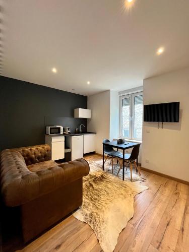 un salon avec un canapé et une table dans l'établissement LesCinqSuites / Le Chivas - DABNB, à Limoges