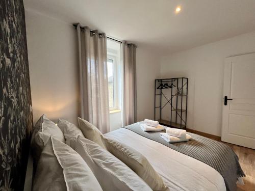 a bedroom with a large white bed with pillows at LesCinqSuites / Le Chivas - DABNB in Limoges