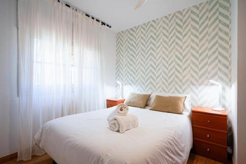 a bedroom with a white bed with a teddy bear on it at Villa Mar in Teià