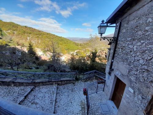 a stone building with a door and a view at Col di Lana in Rocca di Botte