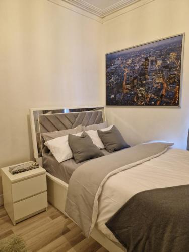 a bedroom with a bed and a painting on the wall at Spacious and homely one bedroom in London