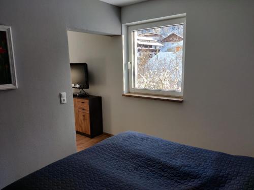a bedroom with a blue bed and a window at Apartment am Mühlbach in Reith bei Seefeld