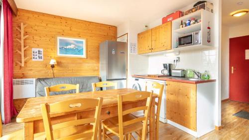 - une cuisine avec une table et des chaises en bois dans la chambre dans l'établissement V du Bachat EPICEA C02 - Appt 5 pers, à Chamrousse