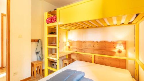 Un dormitorio con una litera y una litera amarilla. en V du Bachat EPICEA C02 - Appt 5 pers, en Chamrousse