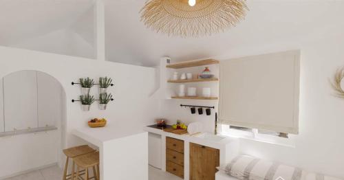 a kitchen with white walls and a chandelier at Petra Mare Village in Kerveli