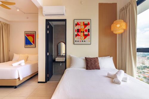ein Schlafzimmer mit einem weißen Bett und einem Fenster in der Unterkunft Urban Suites, Autograph Collection by Stellar ALV in Jelutong