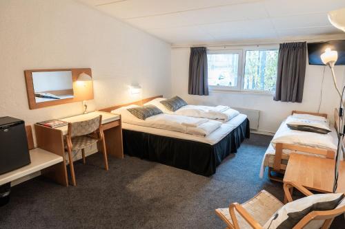 a hotel room with two beds and a desk at Hotel Herning in Herning