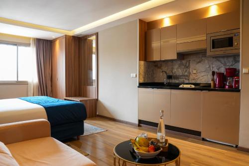 una camera d'albergo con un letto e un cesto di frutta su un tavolo di First Suites Hôtel a Rabat