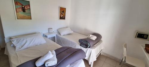 two beds in a white room with towels on them at Xanthoula rooms -ενοικιαζομενα δωμάτια Ξανθουλα in Amaliápoli