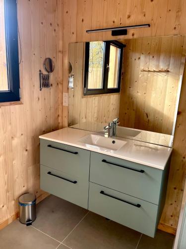 une salle de bain avec un lavabo blanc et un miroir dans l'établissement La cabane 56 - calme - cosy - confortable - sois les chênes - sans vis-à-vis, à Lège-Cap-Ferret