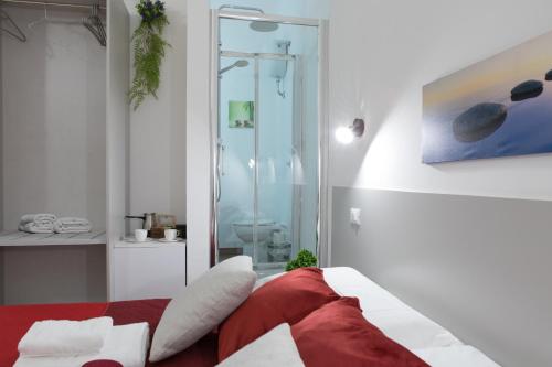 um quarto com uma cama vermelha e uma cabina de duche em vidro em Luxury Suite - Teatro Romano - Duomo - Centro Storico Wi-Fi em Terracina