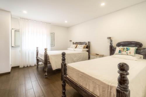 um quarto com 2 camas e uma janela em Madeira Bird House - House in the Mountains With Garden em São Vicente