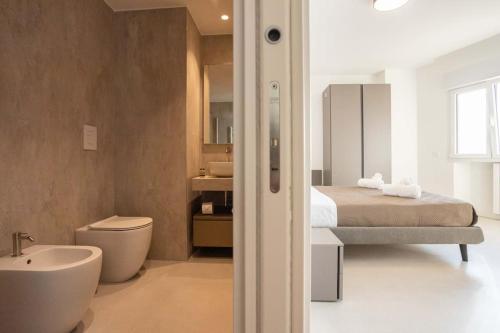 a bedroom with a bed and a bathroom with a sink at Luxury Cefalù Santa Maria in Cefalù