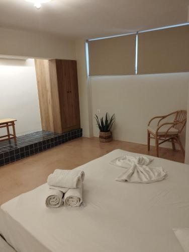 a room with a bed with two towels on it at Dolphins in Korinthos