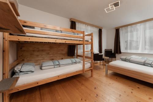 2 Etagenbetten in einem Zimmer mit Holzböden in der Unterkunft Haus Attos in Umhausen