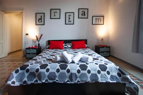 Un dormitorio con una cama en blanco y negro con almohadas rojas en Red House Ostiense Historic building, en Roma