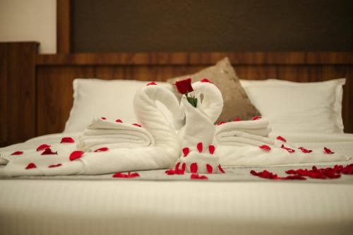 a bed with two swans made out of towels at ARIAT AVENUE in Wayanad