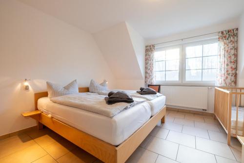 a bedroom with a bed in a room with a window at Strandglück 3 in Zingst