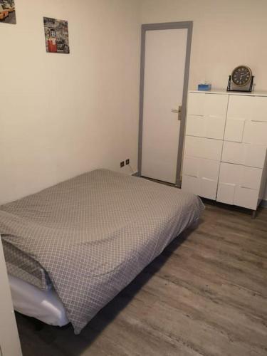 une chambre avec un lit dans le coin d'une pièce dans l'établissement LE PETIT BESSE - Calme - Centre Ville - Thermes, à Vichy