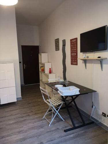 Cette chambre comprend une table et un bureau avec une chaise. dans l'établissement LE PETIT BESSE - Calme - Centre Ville - Thermes, à Vichy