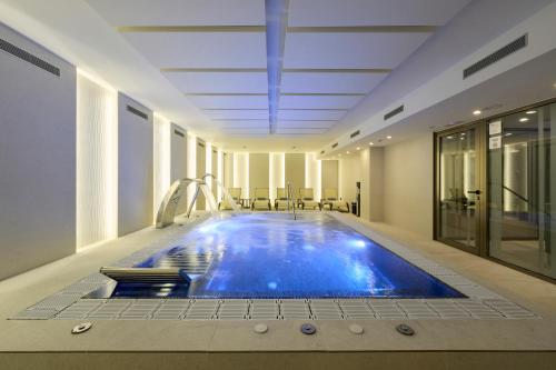 a large swimming pool in a hotel room with a pool at Catalonia La Maquinista in Barcelona