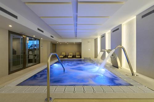 a hot tub in a hotel room with blue water at Catalonia La Maquinista in Barcelona